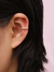 Close-up of a gold-plated ear cuff with sparkling pavé cubic zirconia on an ear