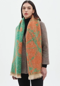 Detail of soft jacquard knit scarf with orange and green floral patterns and fringe edges