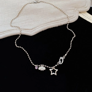 Close-up of silver pentagram necklace with purple gemstone on textured fabric