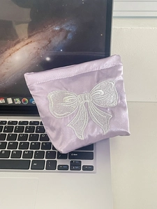 Purple satin makeup bag with white bow embroidery and elastic closure for small items
