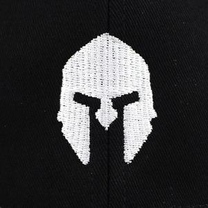 Dettaglio del ricamo bianco del casco spartano su un cappellino in cotone nero