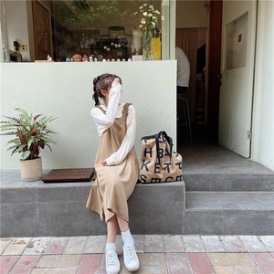 Chic lifestyle view of a woman wearing a camel strap midi dress and white long sleeve top