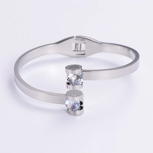 Detail of silver stainless steel open bangle with two cubic zirconia and Roman numerals