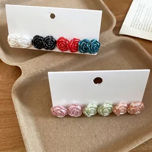 Elegant multi-colored rose stud earring set with pearl finish on display card