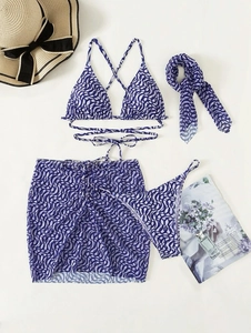 Flat lay of purple geometric bikini set with matching sarong, headscarf and straw hat