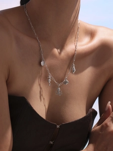 Silver necklace with ocean pendants like seahorse, shell, and octopus on a model