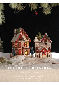 Détail de maisons de Noël en bois éclairées avec pommes de pin et neige artificielle