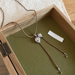 Vintage heart pendant with zircon on braided brown cord inside a rustic wooden gift box