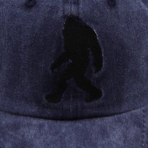 Close-up of the black Bigfoot silhouette embroidery on the washed navy baseball cap