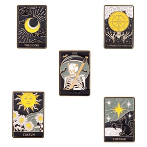 Five-piece set of black and gold tarot card enamel pins featuring sun moon and death motifs