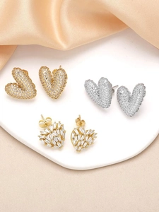 Detailed view of heart stud earrings with cubic zirconia in gold and silver finish