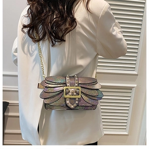 Detail of holographic purple and green scale crossbody bag with gold chain and pearls