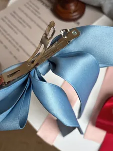 Détail de la pince à cheveux noeud satin bleu clair avec clip métal gravé Paris