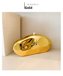Close-up of golden irregular stone-shaped clutch bag with polished metallic mirror finish