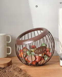 Brown metal wire coffee capsule basket with COFFEE tag on wooden tray with mugs