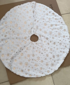 Detail of white plush Christmas tree skirt with festive gold sequined snowflake patterns