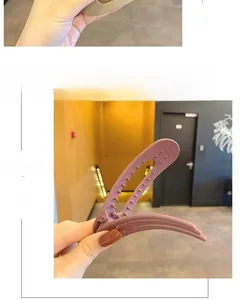 Detail of matte pink hair clip showing internal non-slip teeth and metal spring