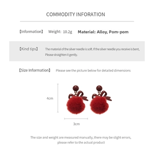 Detail view of red pompom bow earrings showing dimensions of 4cm by 3cm and 10.2g weight