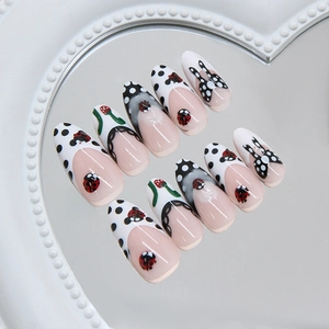 Chic almond press on nails with ladybug and polka dot bow on mirror tray