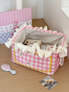 Pink and white checkered laundry basket with ruffle edges and pearl handles