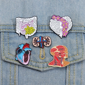 Vue détaillée de pins en émail anatomie avec cœur et côtes sur une veste en jean