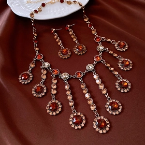 Gros plan sur un ensemble collier et boucles vintage dorés avec pierres ambrées