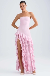 Détail d'une robe de soirée rose bustier avec des volants et une fente latérale sexy