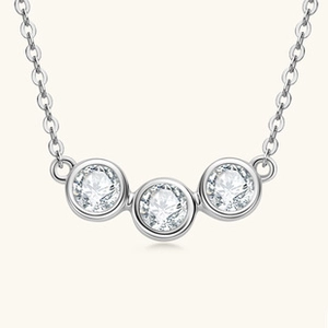 Detailed macro view of three round-cut moissanite stones set in silver heart necklace