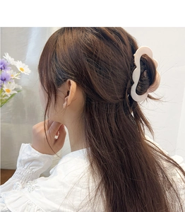 Close-up of a large cream matte wave hair claw clip securing a half-up hairstyle