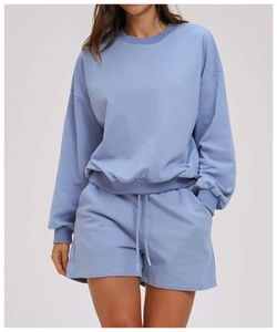 Detail of light blue crewneck sweatshirt with ribbed cuffs and matching drawstring shorts
