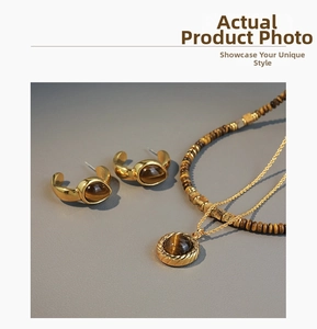Detailed close-up of vintage 18K gold plated tiger eye stone necklace and C-shaped earrings