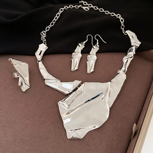 Detailed set of silver irregular liquid metal necklace, earrings and ring on a tray