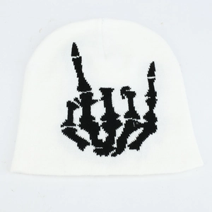Détail du bonnet blanc tricoté avec broderie noire de geste de main de crâne pour l'hiver