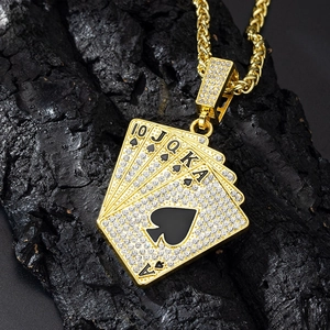 Close-up of golden royal flush poker pendant with sparkling zircons on a dark rock
