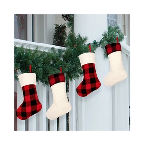 Set of 4 red and black plaid Christmas stockings hanging on a festive pine garland