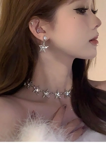 Gros plan d'un mannequin portant un collier ras du cou étoile et boucles d'oreilles