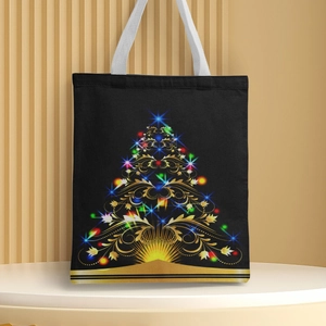 Detail of a black Christmas canvas tote bag featuring a golden tree and white handle