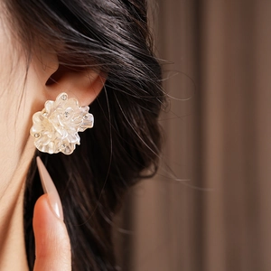 Vue macro de boucles d'oreilles fleur plaquées or avec cristaux sur un mannequin