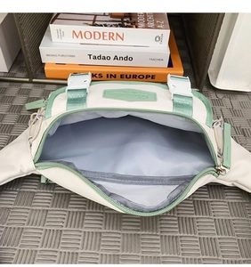 Detail view of large capacity crossbody waist bag with mint green strap and grey lining