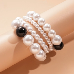 Gros plan sur un ensemble de bracelets multicouches en perles blanches et noires de qualité