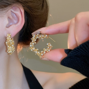 Close-up of gold star-studded hoop earrings with sparkling micro-pave zirconia crystals