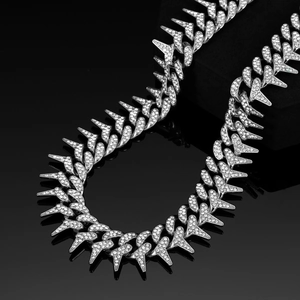 Macro shot of silver-toned 20mm Cuban link necklace with sharp spikes and clear rhinestones