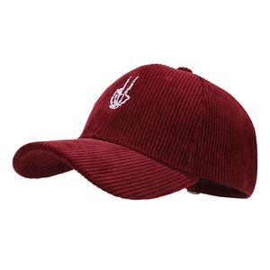 Burgundy corduroy baseball cap featuring a white skeleton hand embroidery and curved brim