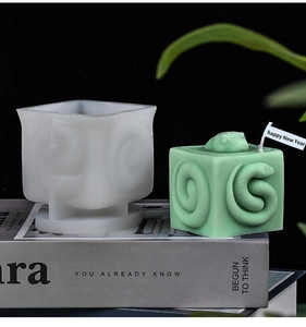 Macro view of square silicone mold and 3D snake relief candle with Happy New Year flag