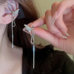 Gros plan sur un protège-oreille papillon argenté avec zircon et chaînes à franges