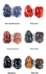 Detail view of mini hand-carved frog figurines in various natural gemstones and crystals