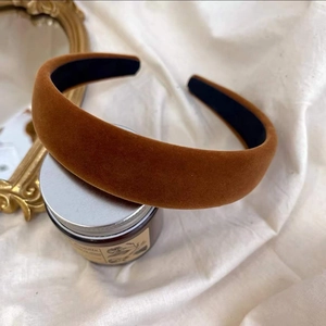 Serre-tête en velours marron caramel avec doublure antidérapante sur fond en lin rustique