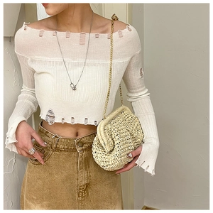 Detailed shot of white off-shoulder knit crop top featuring stylish distressed hem and cuffs
