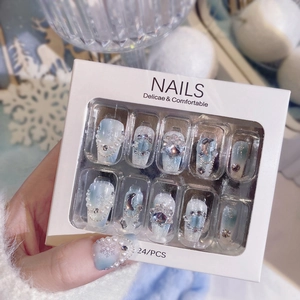 Close-up of gradient blue snowflake press-on nails with pearl and rhinestone accents