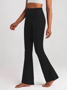 Detail of high-waisted flared yoga pants showing tummy control and black athletic fabric